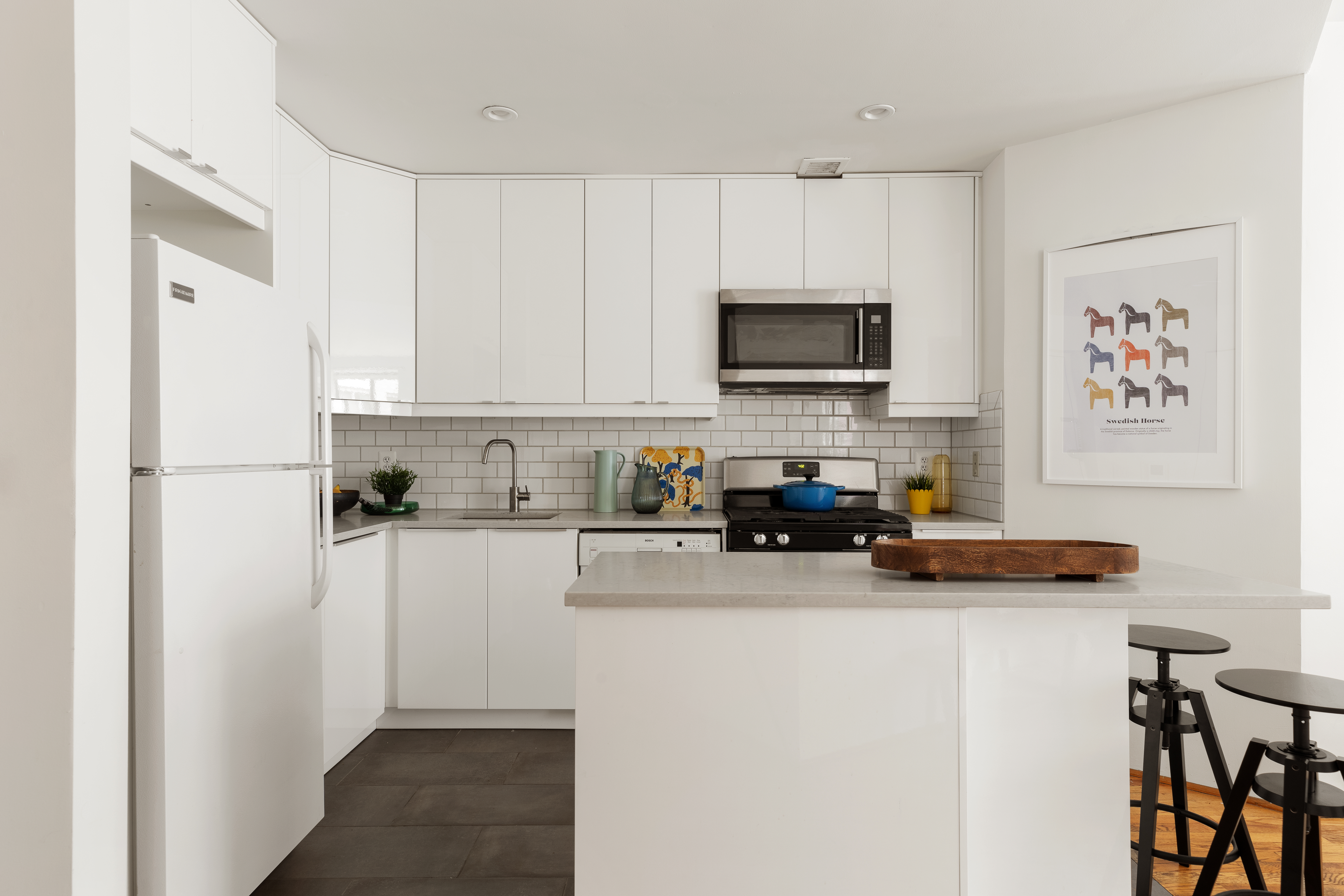 167 Perry Street, Unit 4K Manhattan, NY 10014 - Photo 5 of 11 a kitchen with a refrigerator a stove a microwave and cabinets