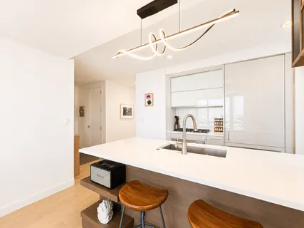 a living room with stainless steel appliances kitchen island granite countertop furniture and a large window