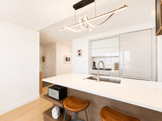 22 North 6th Street, Unit 23K Brooklyn, NY 11249 - Photo 4 of 11 a living room with stainless steel appliances kitchen island granite countertop furniture and a large window