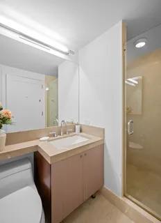 a bathroom with a sink a toilet and shower