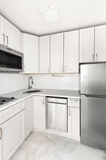 a kitchen with white cabinets and white appliances