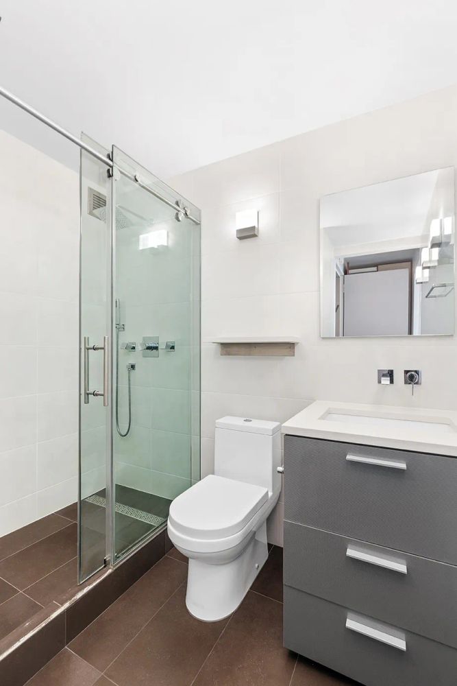 236 East 47th Street, Unit 27DE Manhattan, NY 10017 - Photo 8 of 16 a bathroom with a toilet a sink and shower