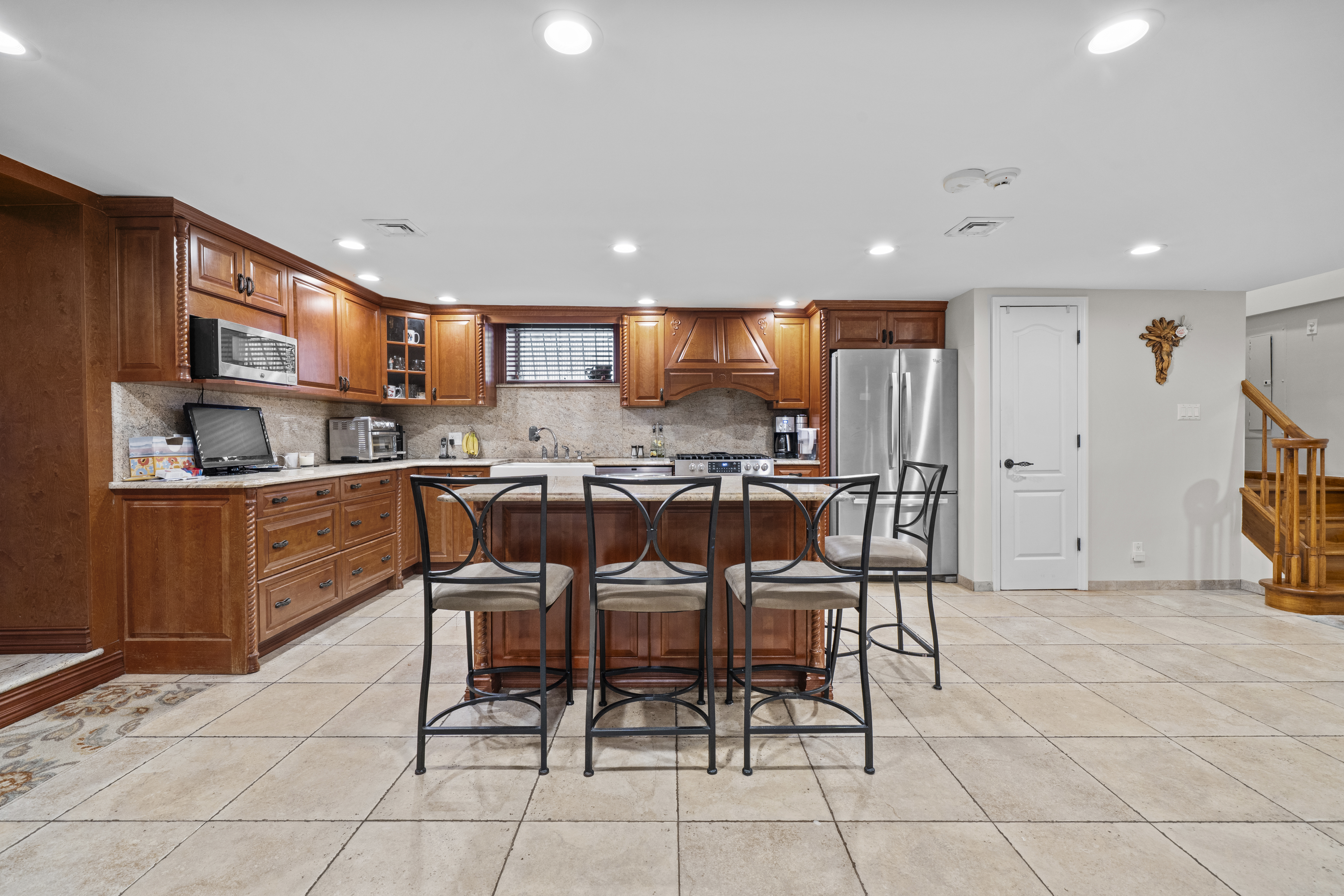2253 East 64th Street Brooklyn, NY 11234 - Photo 27 of 45 a kitchen with stainless steel appliances kitchen island granite countertop a sink and a refrigerator