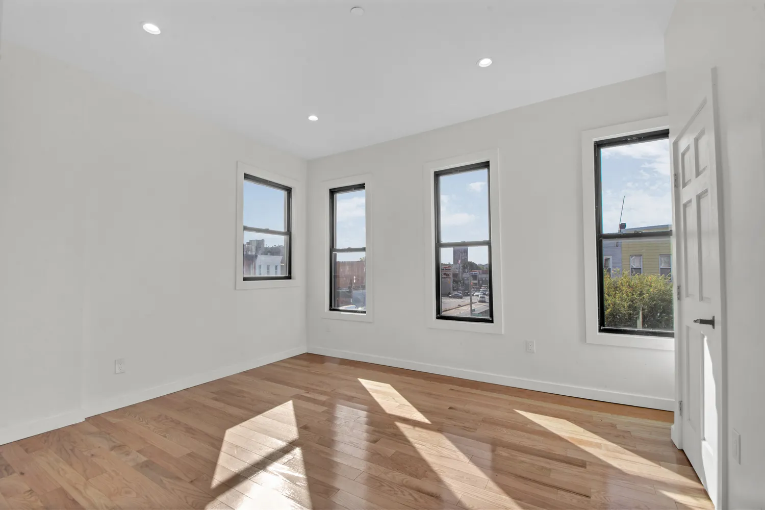 a view of a bedroom with wooden floor and windows
