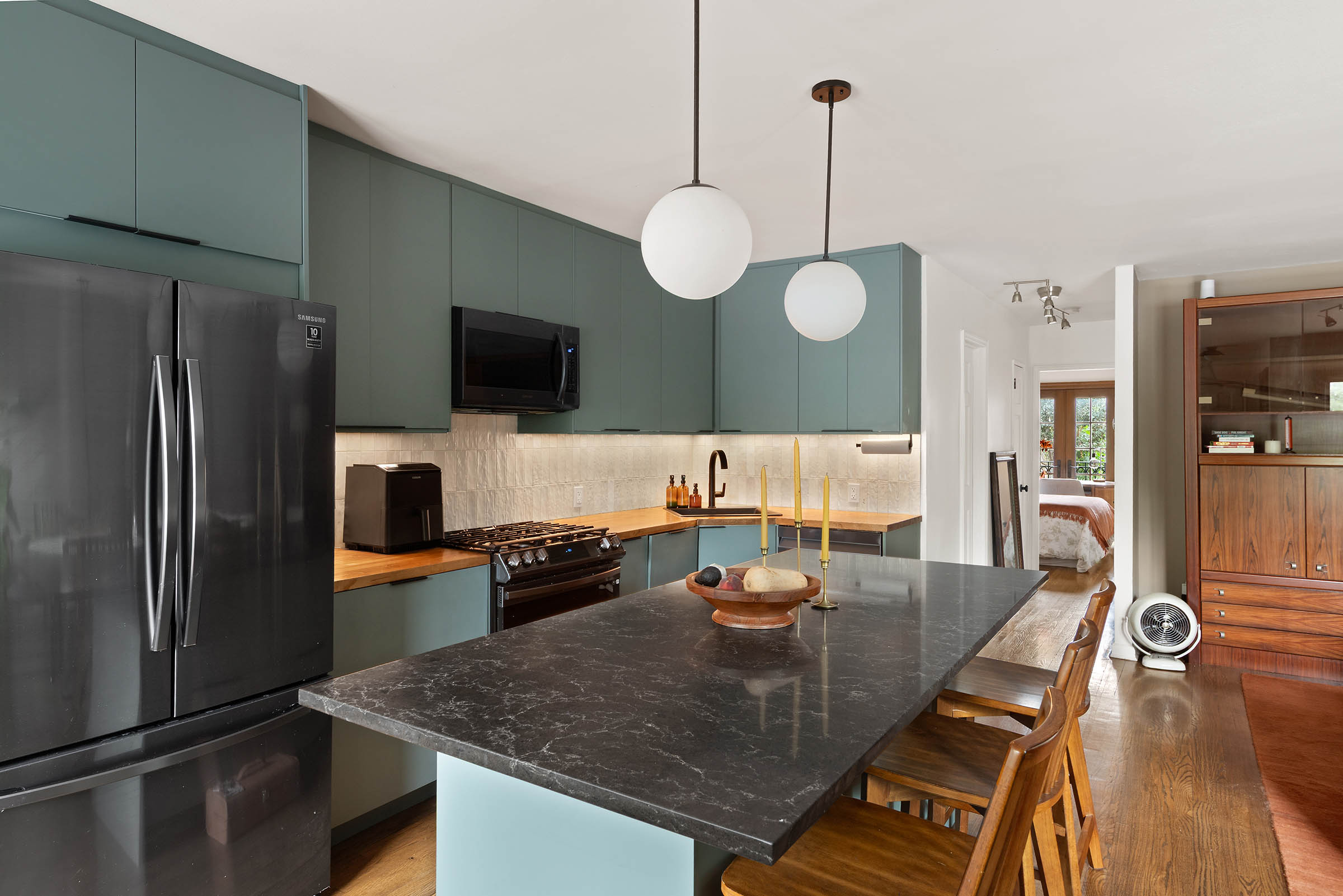 209 Onderdonk Avenue Queens, NY 11385 - Photo 4 of 16 a large kitchen with a table chairs stainless steel appliances and cabinets