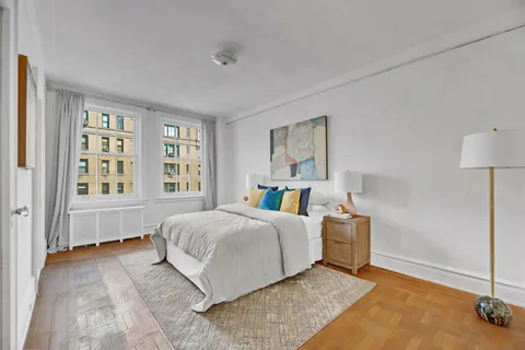 a living room with a bed furniture and next to a window