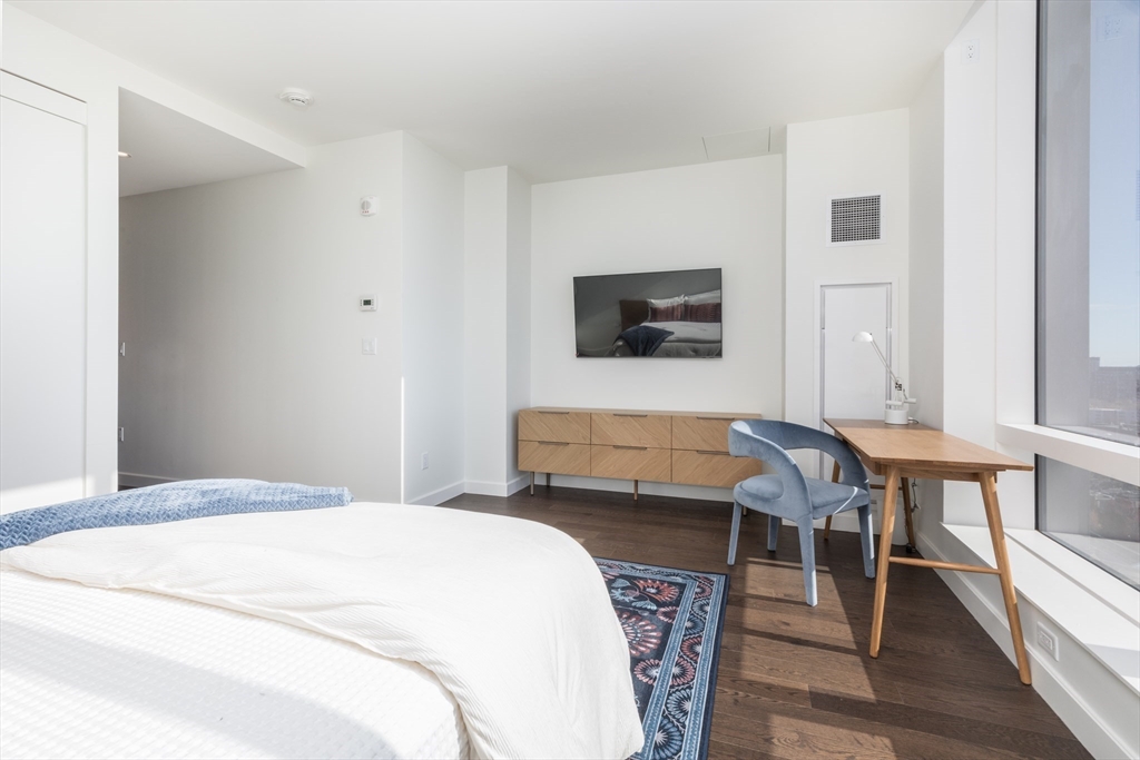 40 Trinity Place, Unit 1606 Boston, MA 02116 - Photo 6 of 17 a bedroom with a bed and a flat screen tv