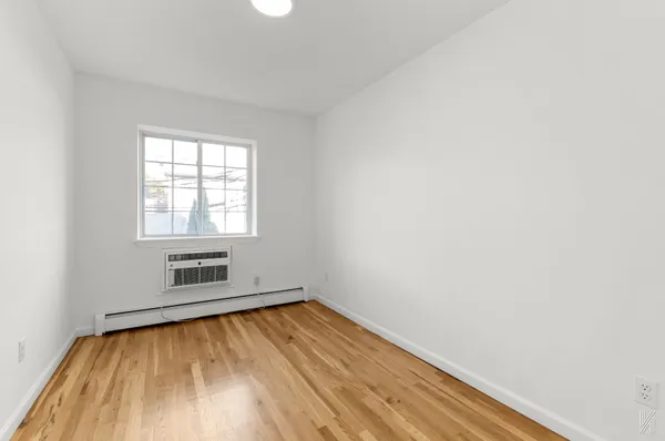 an empty room with a hardwood and a window