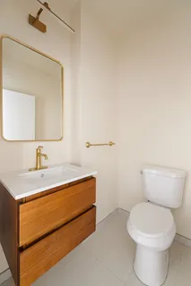 a bathroom with a sink a toilet and mirror