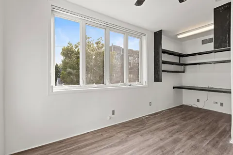 a view of a room with wooden floor and windows
