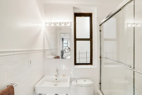 a bathroom with a sink a toilet and shower