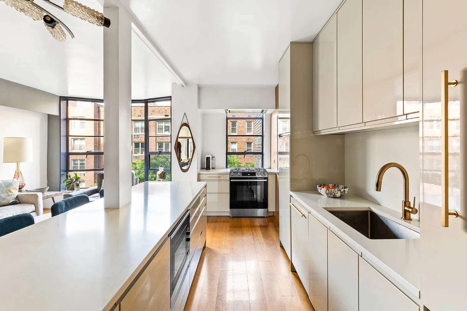 a kitchen with stainless steel appliances a sink a counter top space and living room view