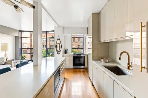 a kitchen with stainless steel appliances a sink a counter top space and living room view