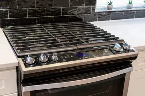 a kitchen with granite countertop white cabinets stainless steel appliances and a sink
