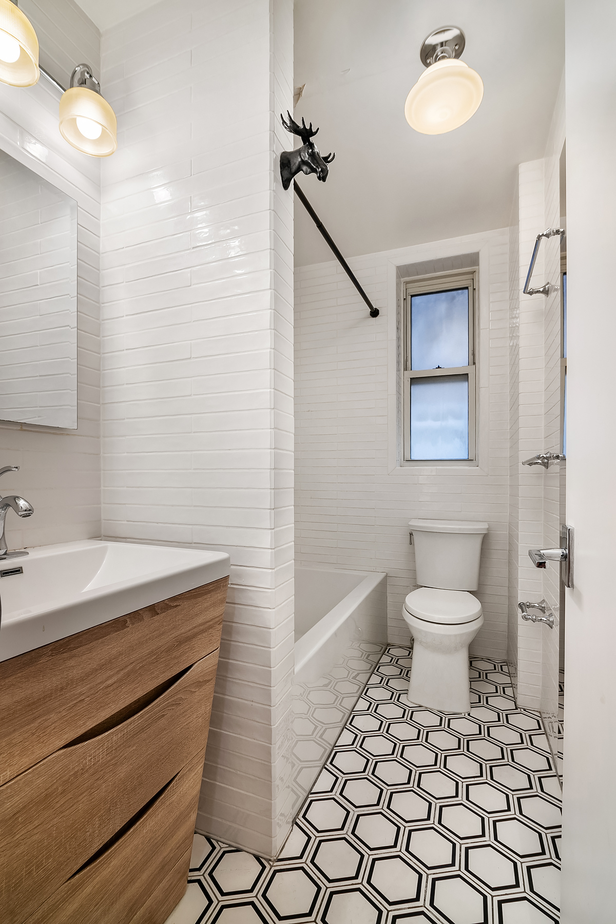 305 West 52nd Street, Unit 2J Manhattan, NY 10019 - Photo 11 of 13 a bathroom with a sink toilet and shower
