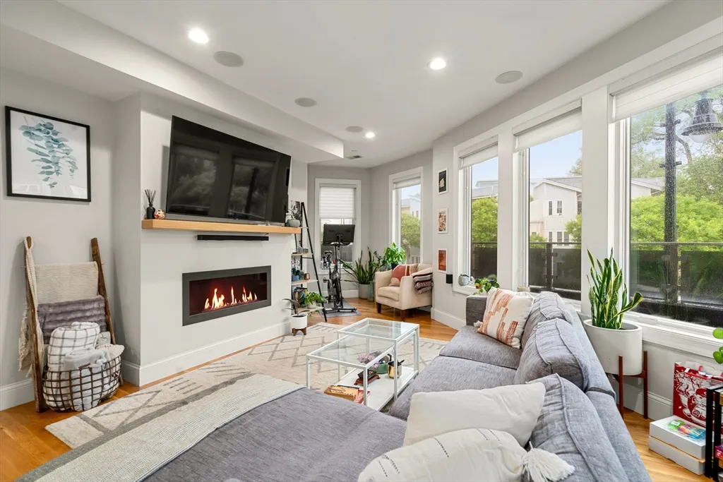 a living room with furniture a flat screen tv and a fireplace