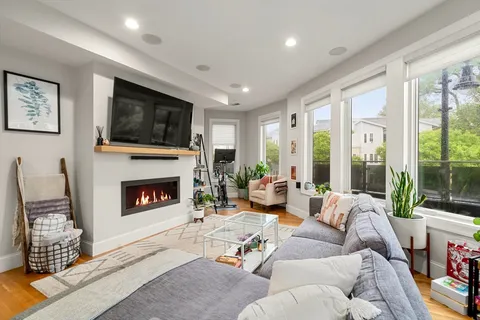 a living room with furniture a flat screen tv and a fireplace