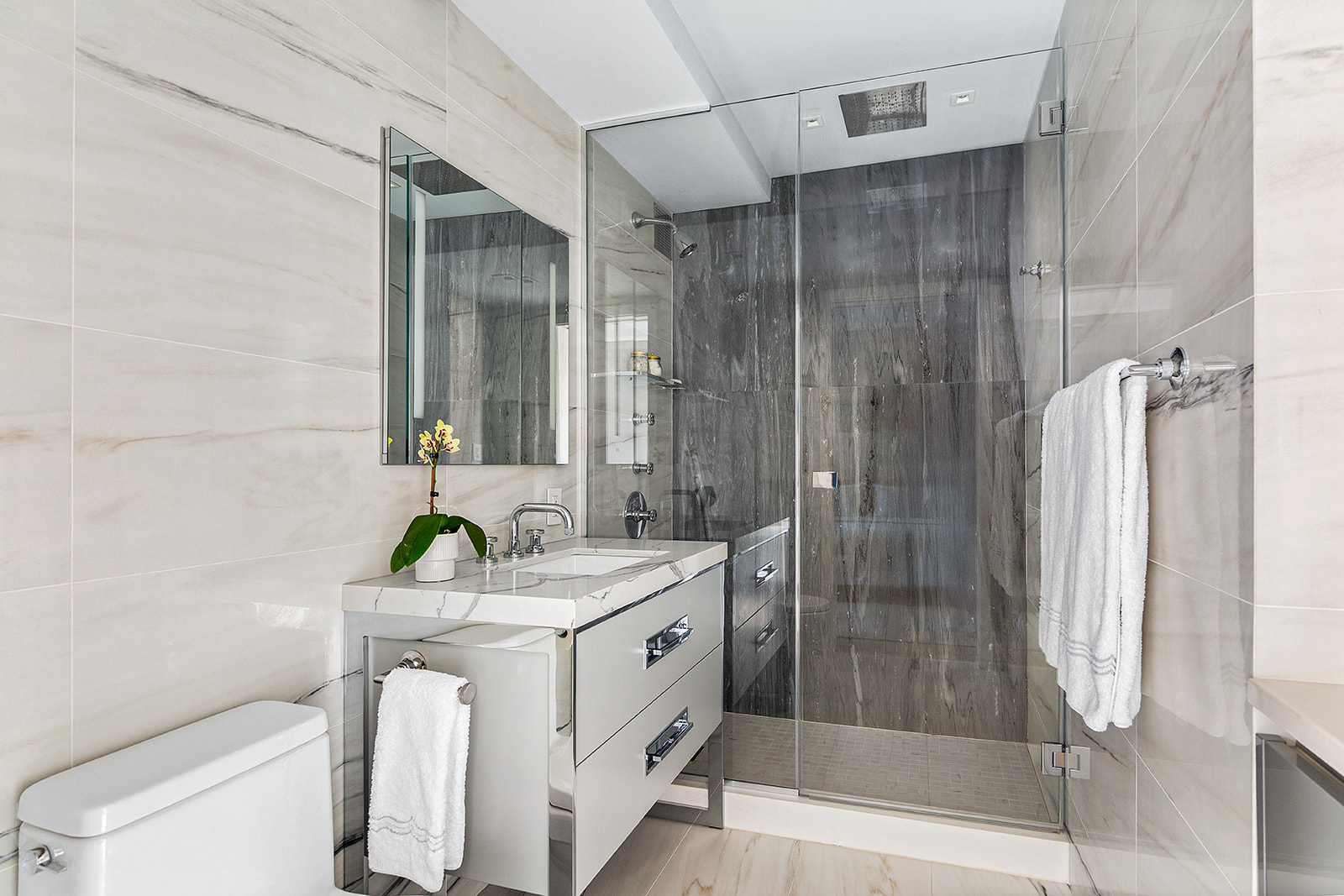 165 East 72nd Street, Unit 17L Manhattan, NY 10021 - Photo 8 of 12 a bathroom with a granite countertop sink a toilet and shower
