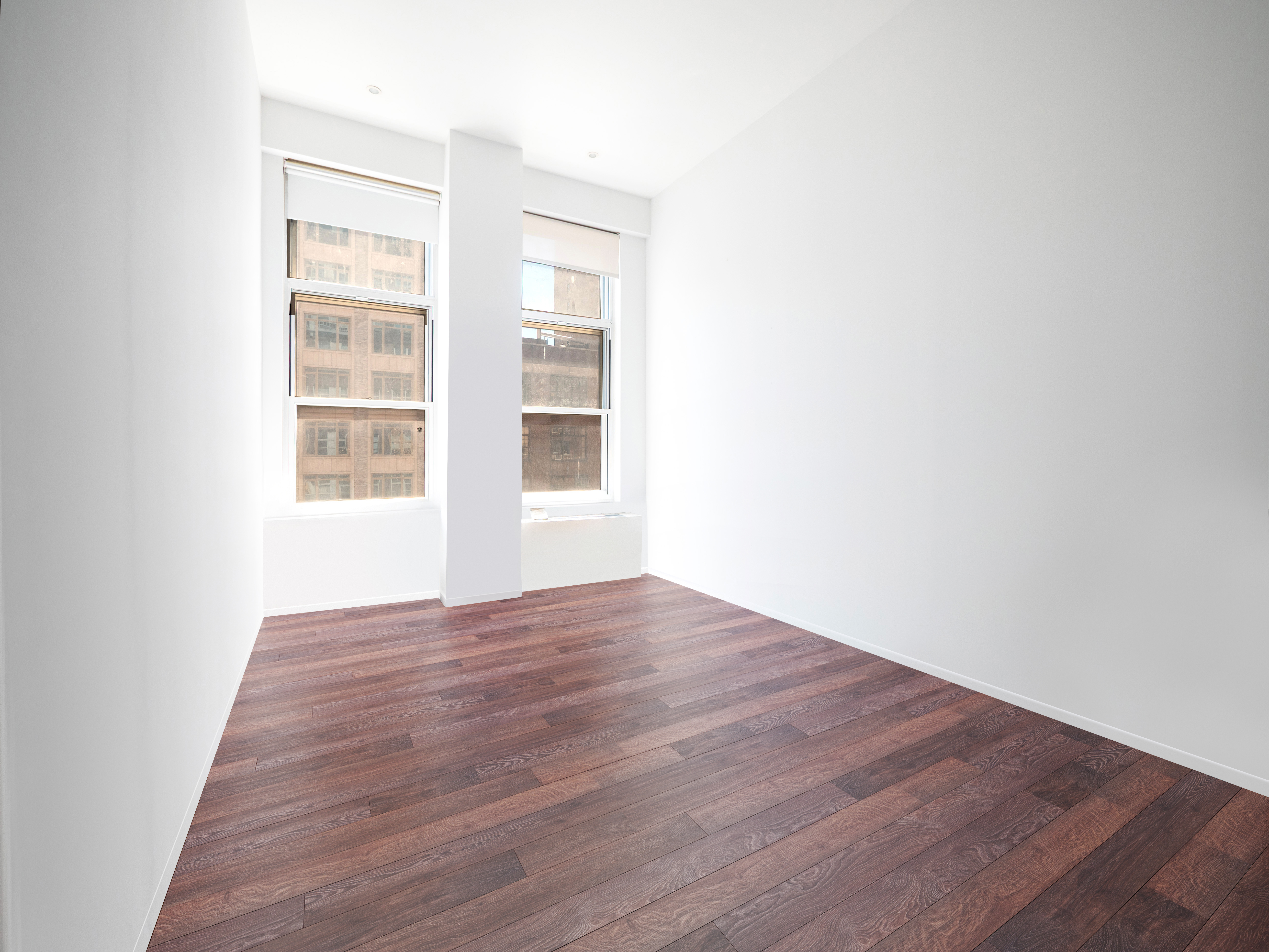 120 East 87th Street, Unit R6IJ Manhattan, NY 10128 - Photo 13 of 27 a view of an empty room with wooden floor and windows