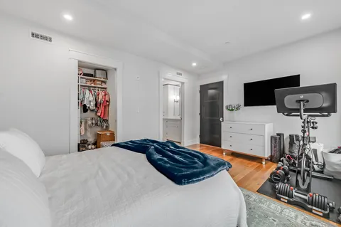 a bedroom with a bed and wooden floor