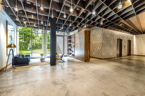 a view of an empty room with wooden floor and windows