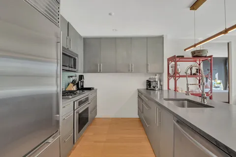 a kitchen with stainless steel appliances granite countertop a sink and a stove