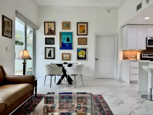 a living room with furniture and paintings on the wall
