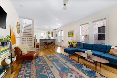 a living room with furniture and wooden floor