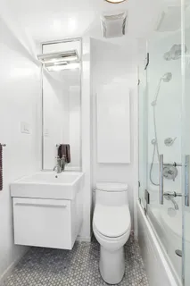 a bathroom with a sink a toilet and shower