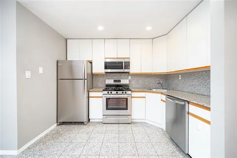 a kitchen with a refrigerator and a stove top oven