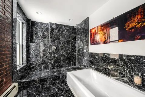 a bathroom with a bathtub sink and mirror