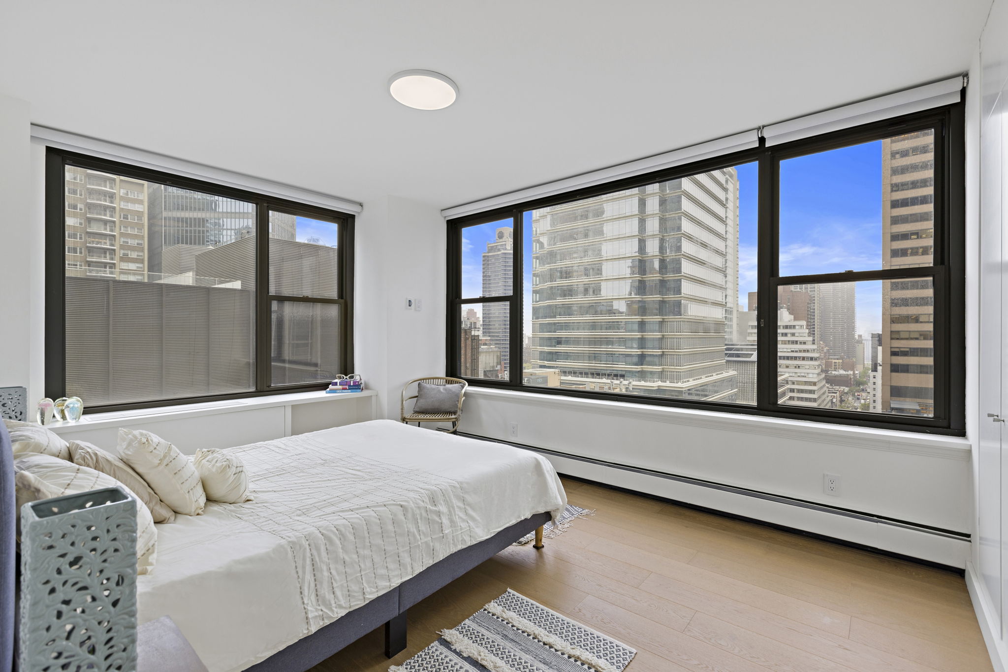 117 East 57th Street, Unit 21H Manhattan, NY 10022 - Photo 9 of 25 a bedroom with a bed and a large window
