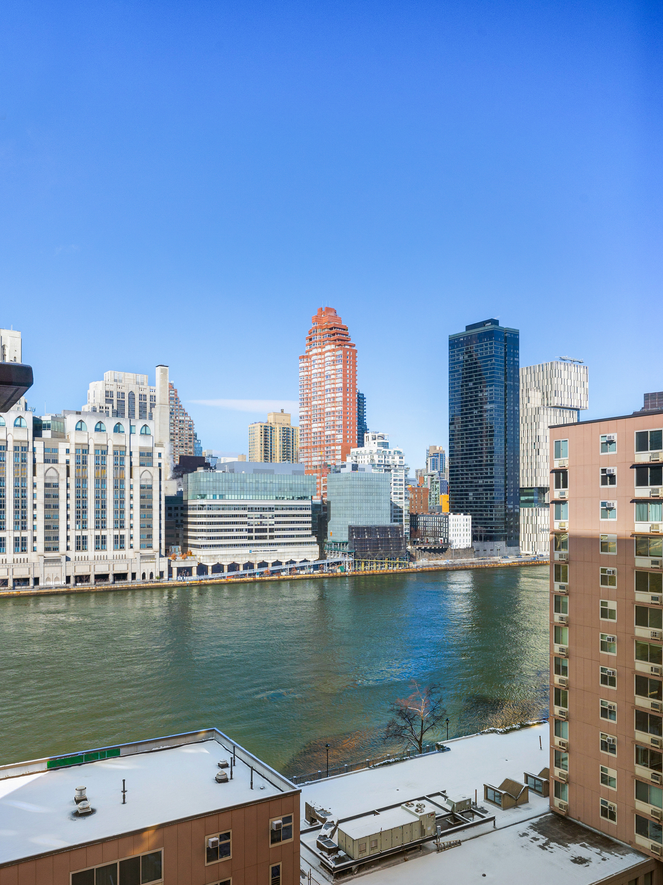 555 Main Street, Unit 1002 Manhattan, NY 10044 - Photo 5 of 12 a view of a lake with tall buildings