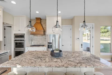 a bedroom with a bed a couch and a large window