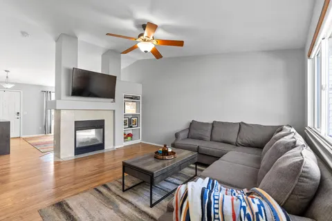 a living room with furniture a flat screen tv and a fireplace