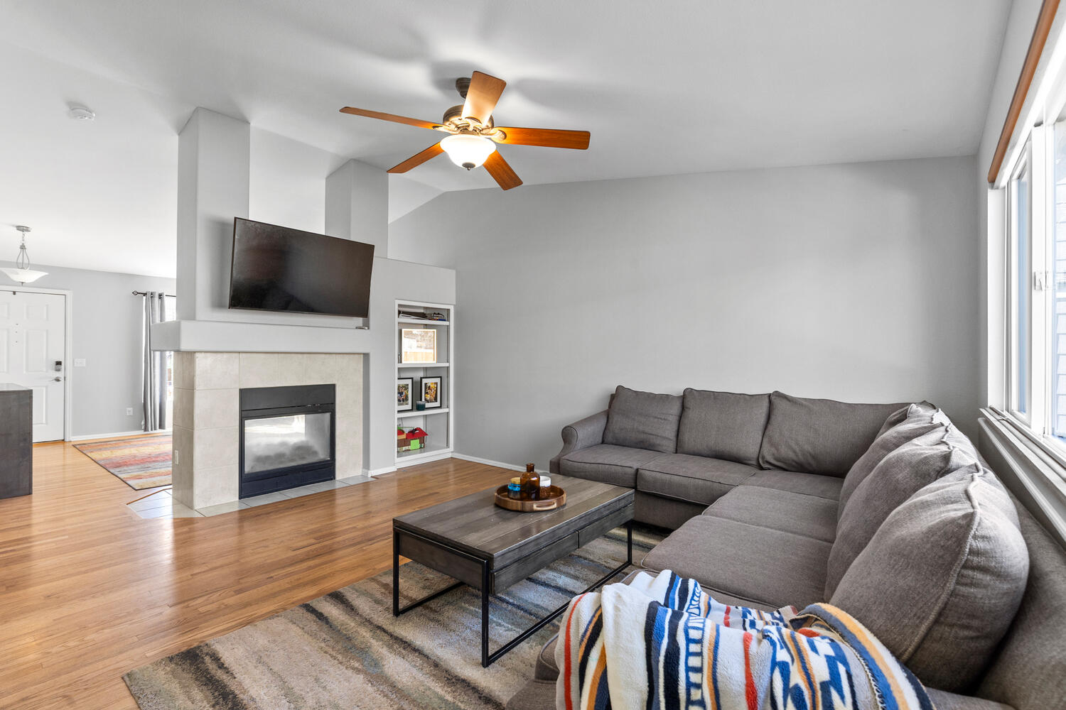 847 Timbervale Trail Highlands Ranch, CO 80129 - Photo 5 of 36 a living room with furniture a flat screen tv and a fireplace