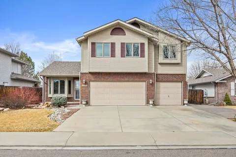 a front view of a house with garage and plants