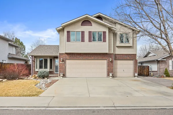 a front view of a house with garage and plants