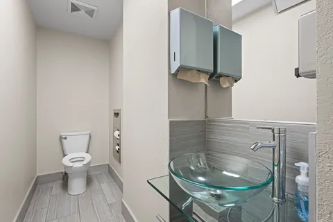 a bathroom with a toilet and a mirror