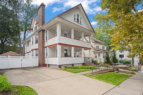 a front view of a house with yard and green space