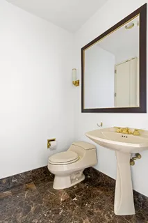 a bathroom with a toilet a sink and mirror