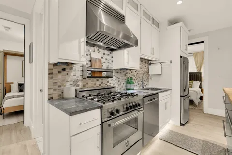 a living room with stainless steel appliances furniture and a refrigerator