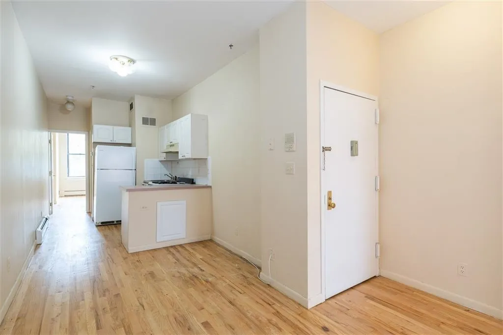 a kitchen with a refrigerator and white cabinets