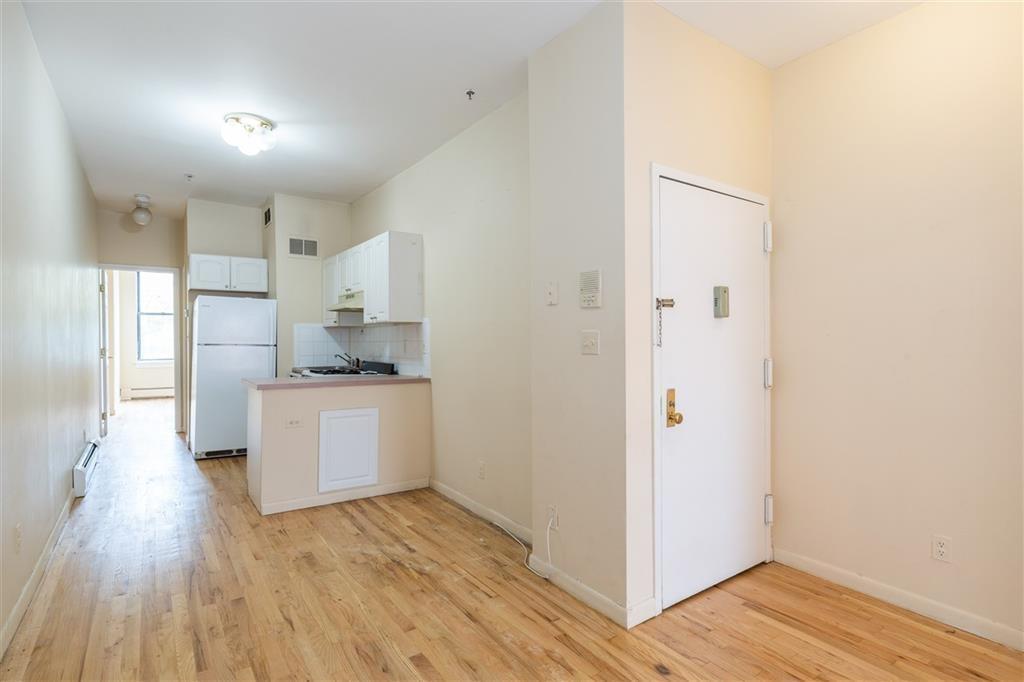 a kitchen with a refrigerator and white cabinets