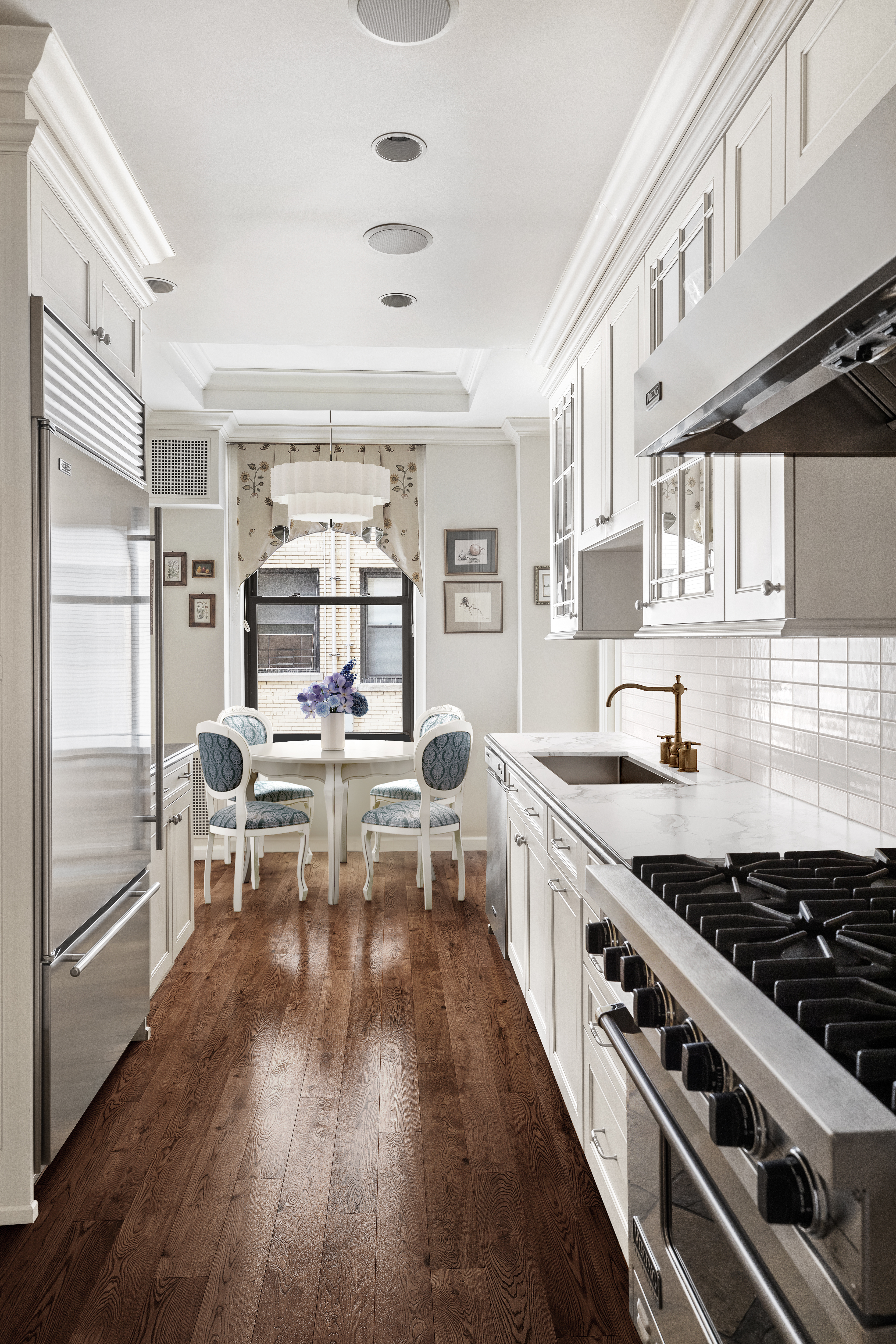 1160 Park Avenue, Unit 8C Manhattan, NY 10128 - Photo 12 of 18 a kitchen with stainless steel appliances a stove a sink dishwasher and cabinets with wooden floor