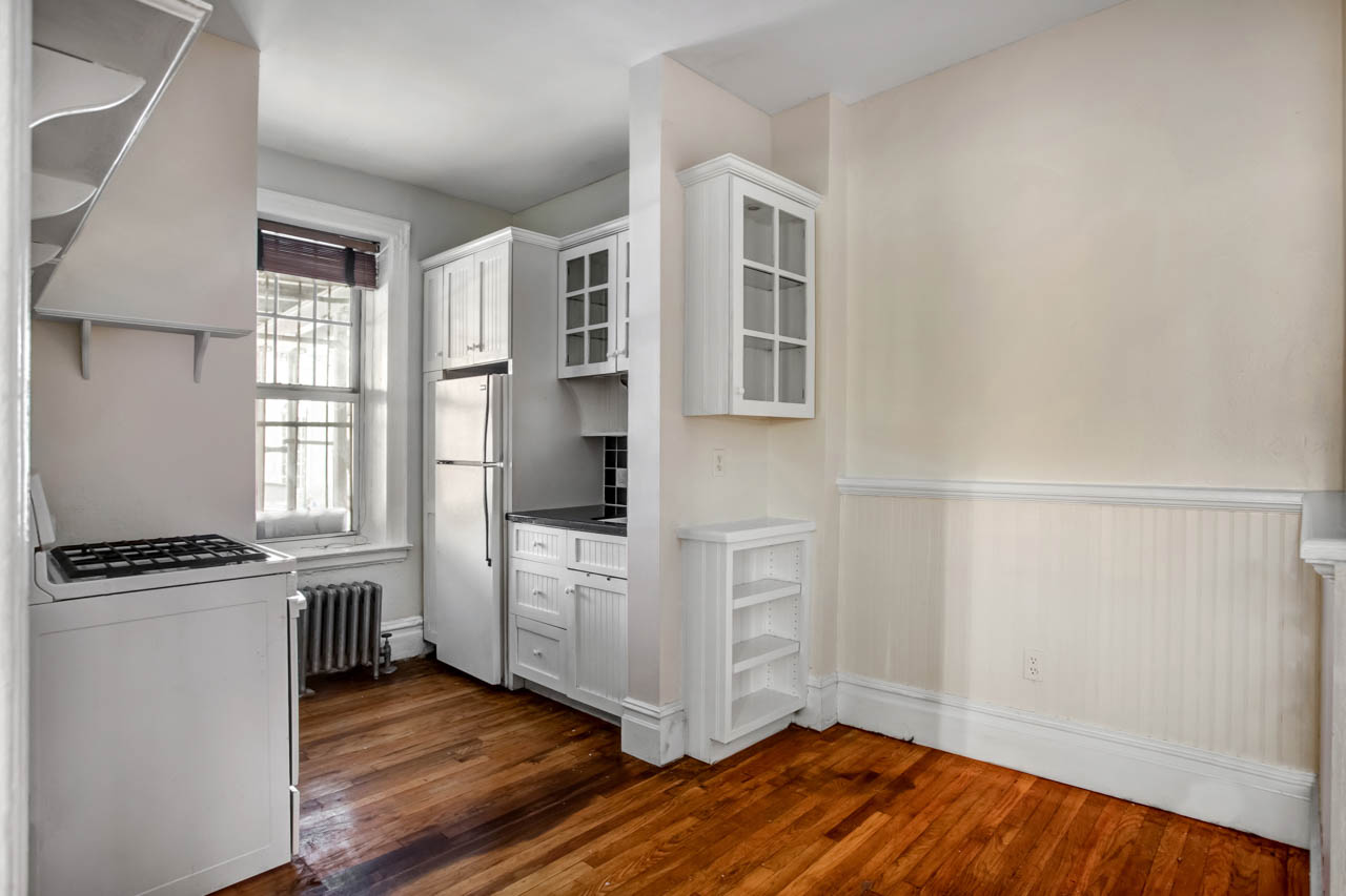 344 West 12th Street, Unit 1A Manhattan, NY 10014 - Photo 9 of 17 an empty room with wooden floor and cabinet