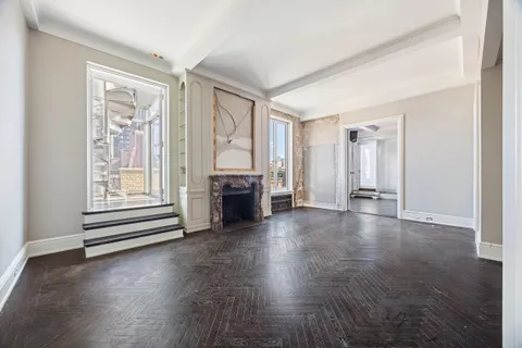 a view of empty room with wooden floor and fireplace
