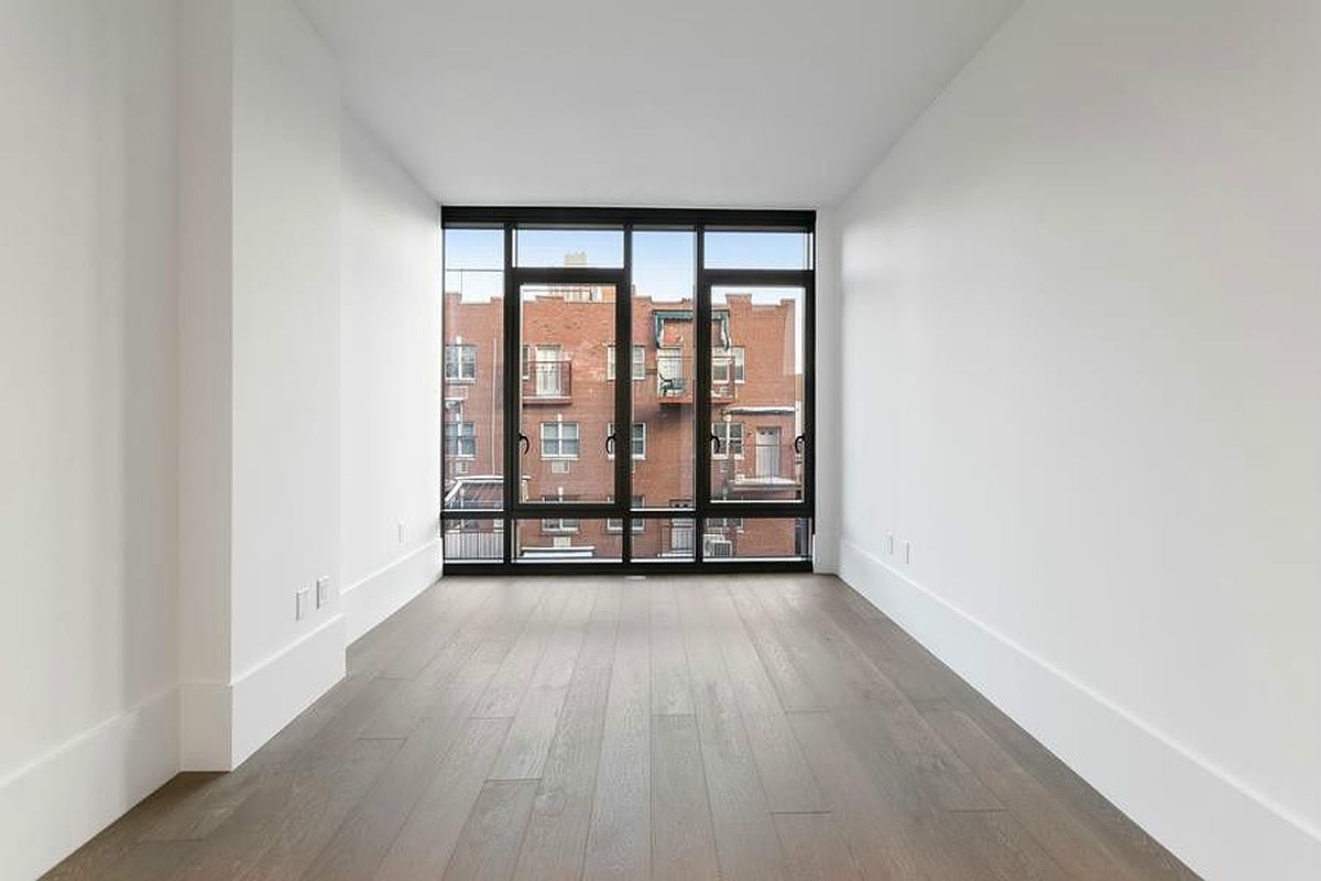 429 Kent Avenue, Unit 607 Brooklyn, NY 11249 - Photo 3 of 14 wooden floor in an empty room with a window