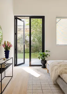 a bedroom with a bed and a large window