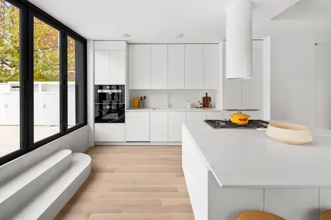 a kitchen with a sink a stove and white cabinets